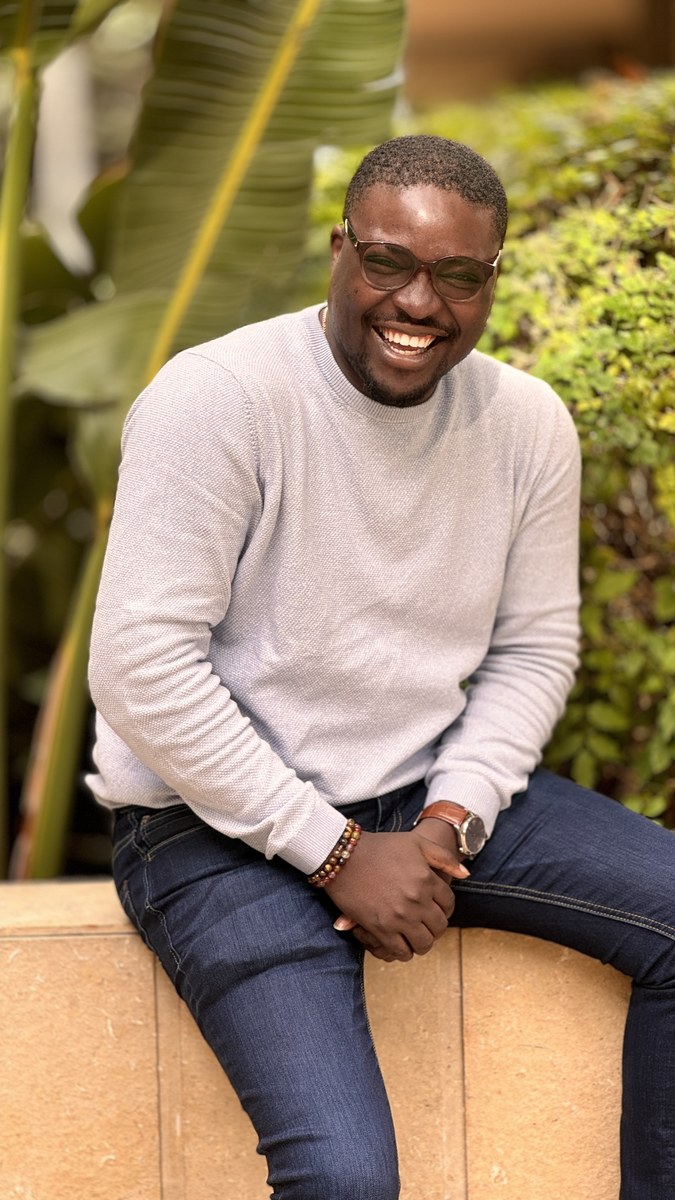 Mayowa Adeoti smiling in an outdoor setting